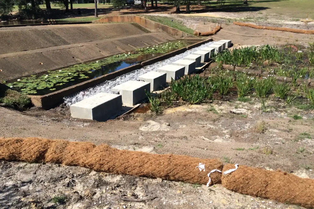 Pond dam, coir sediment wattles and new wetland plantings at a constructed stormwater wetland under construction
