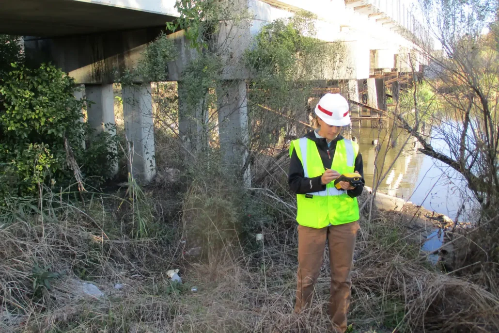 Cypress scientist recording a wetland boundary point on a Trimble GPS unit along the CN rail corridor