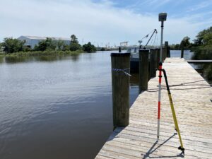 RTK GPS receiver on a bipod setting vertical control on a waterfront dock